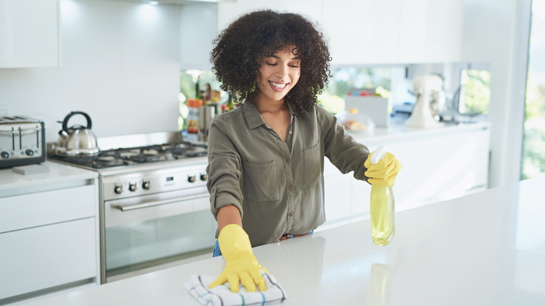 Woman cleaning white countertop