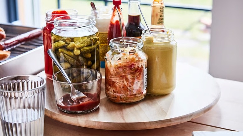 A wooden lazy susan topped with condiments and garnishments