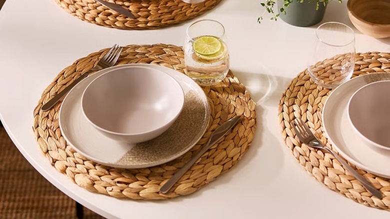 Textured natural placemats under stoneware dishes and silverware