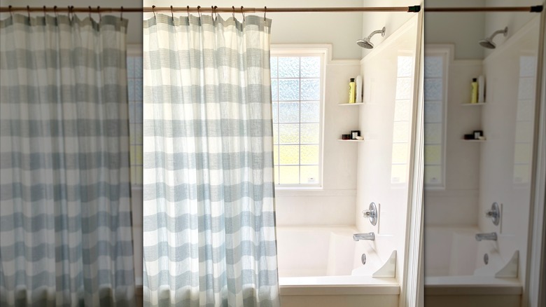 A bright shower with a plaid shower curtain.