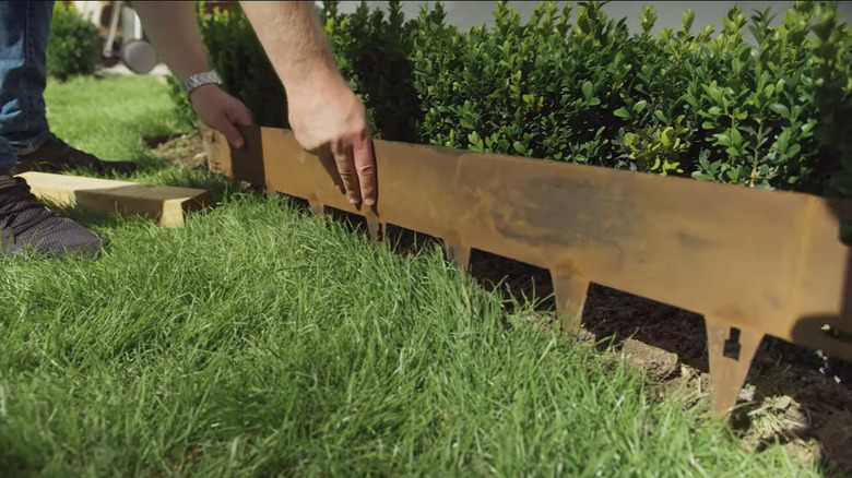 Someone installing garden edging in their yard