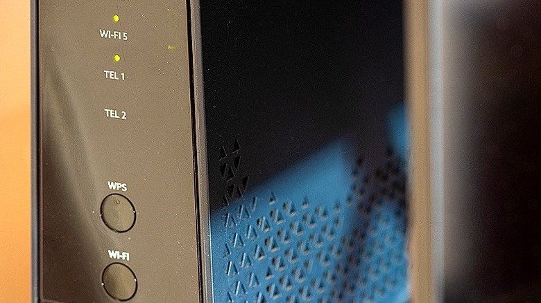 A close-up of the front panel of a Wi-Fi router, showing the signal indicator lights