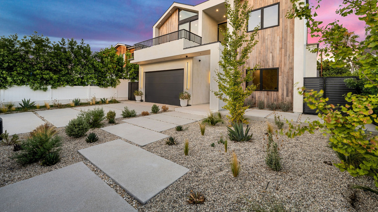 Modern home with a gravel driveway and concrete pavers.