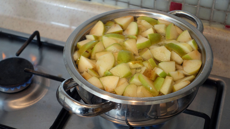 Diced green apples boiling in pot on stove