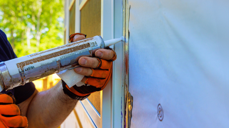 A close-up look of someone caulking a window