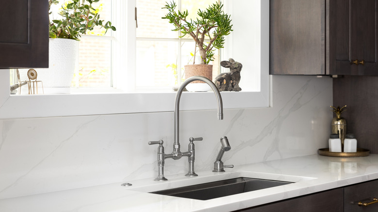 A silver kitchen faucet and sleek sink