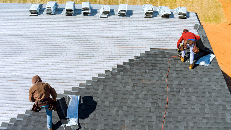 An aerial view of construction workers putting on a roof