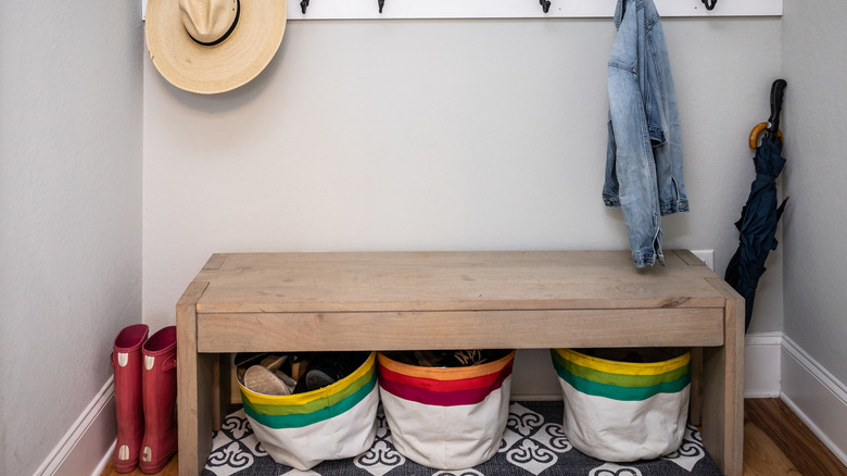 A small entrance mudroom with a hooks for hanging jackets and hats and organization which connects the garage to the house in a new construction home
