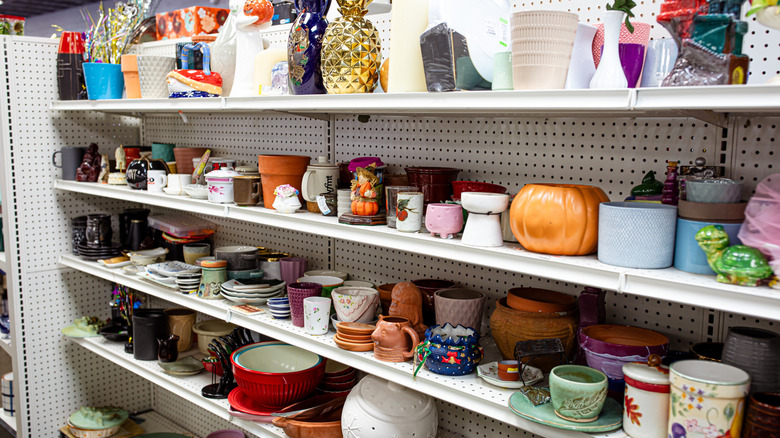 thrift store shelf lined with decor items including plant containers