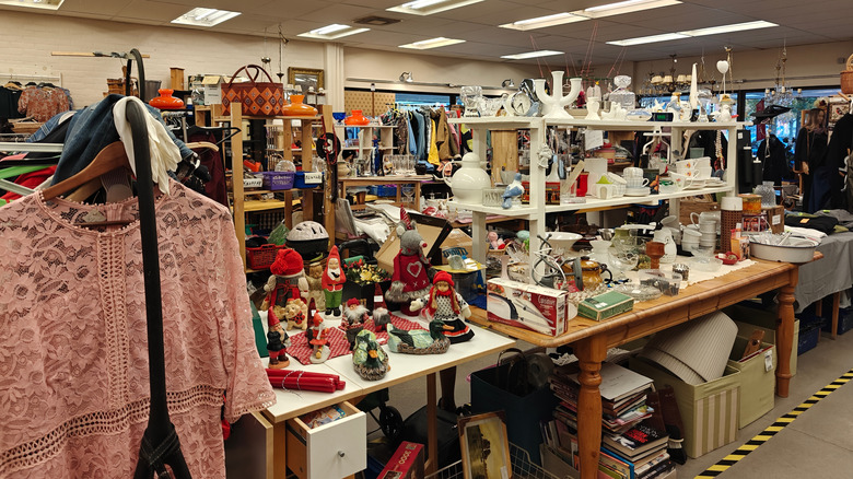 shelves and tables in a thrift store lined with secondhand decor and other items