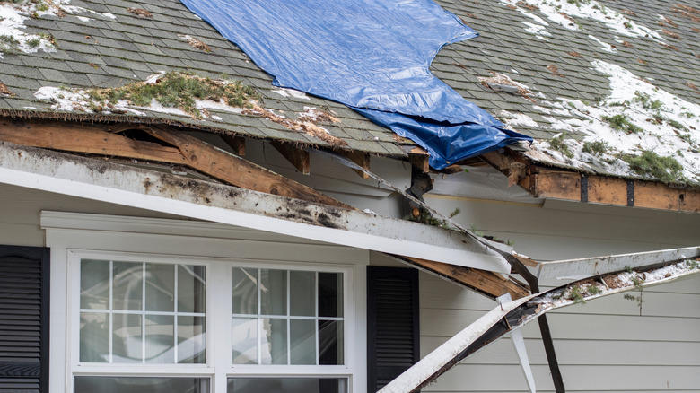 A damaged roof on a residential home due to storms.