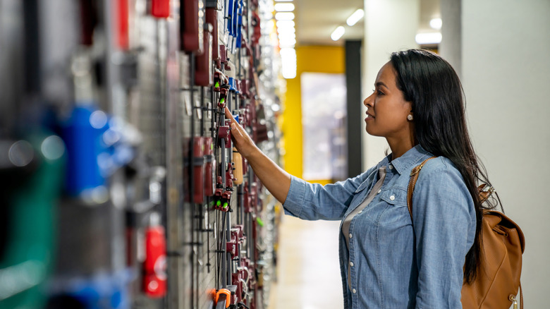 Woman looking at wall of tools in a store