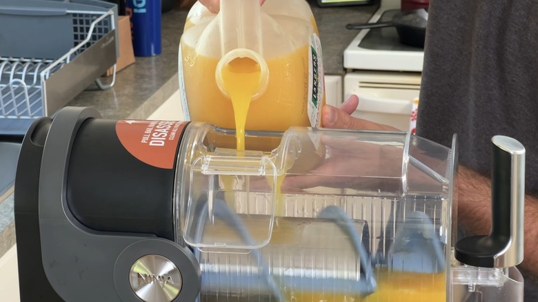 Man pouring orange juice into Ninja SLUSHi machine