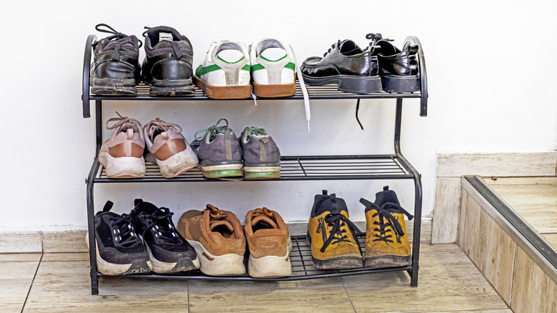a metal shoe rack holding different colors and types of shoes