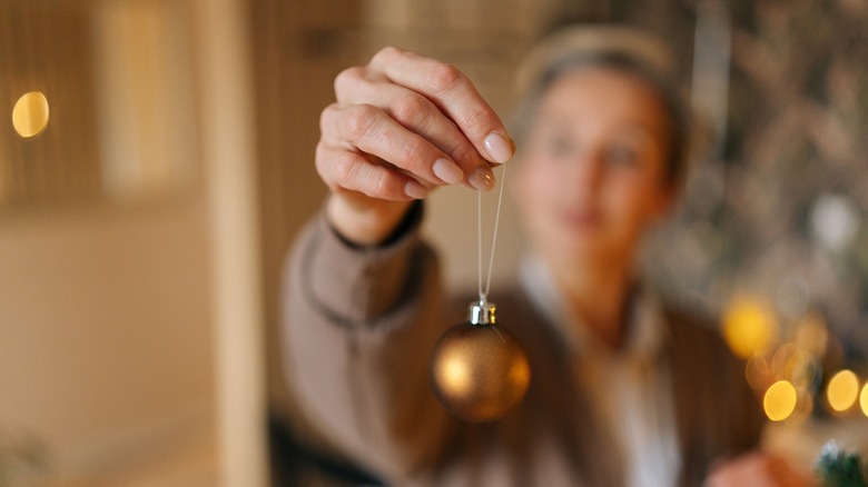 Woman holding out a Christmas ornament