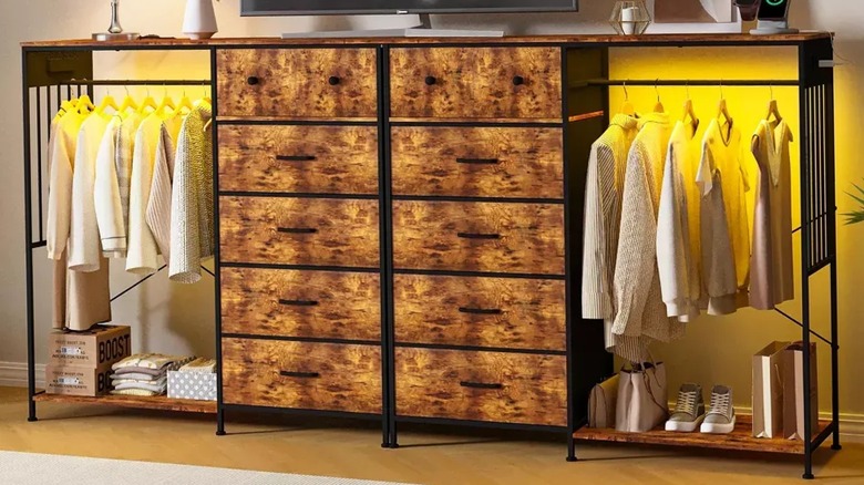 Two dresser and clothes rack combos with pale clothes hung up and trainers and bags sitting underneath.