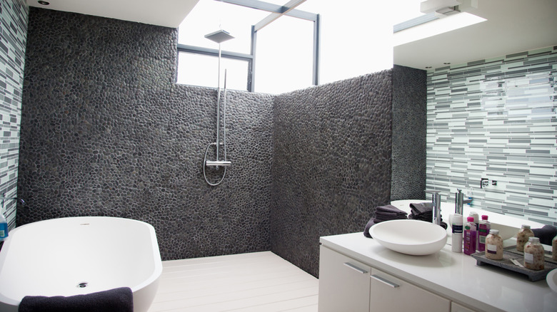 A sleek modern bathroom with an entirely open shower and bath area.