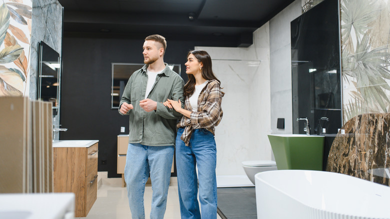 A young couple shop for bathroom accessories and fixtures for a remodel.