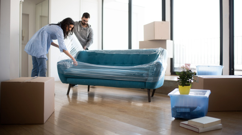 couple unwrapping couch 