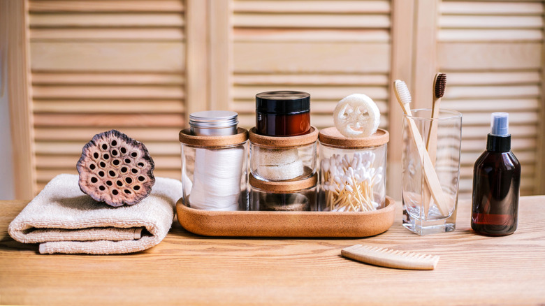 Toiletries in glass jars on a wooden surface in a bathroom
