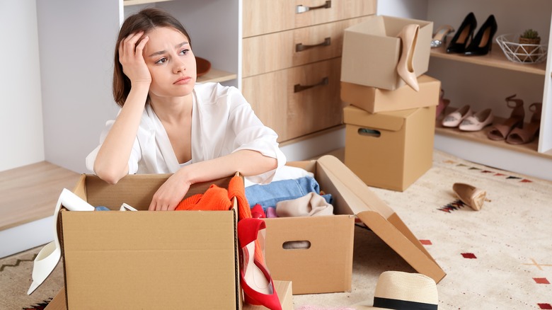 Exasperated woman sitting in clutter