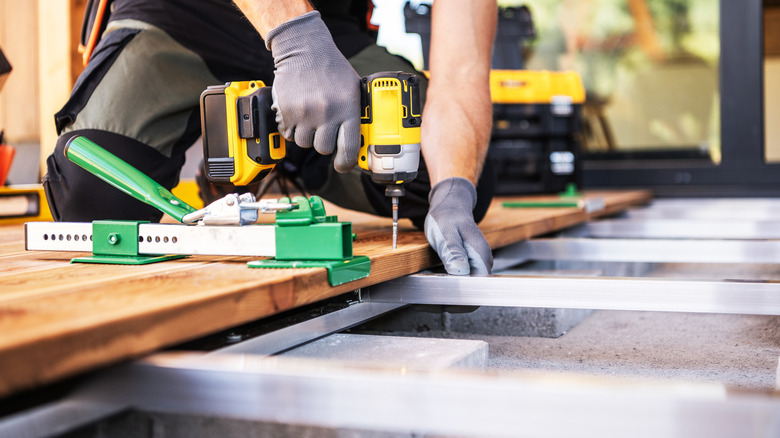 Close-up of a contractor installing a wood deck over a metal frame