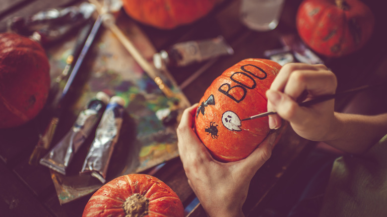 person painting pumpkins