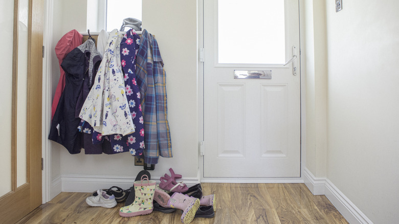 A slightly cluttered entryway with clothes and shoes