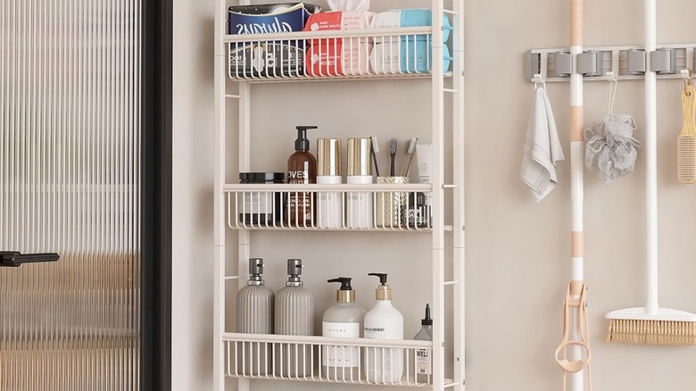 The Umdonx shelf full of various cleaning and bathroom products mounted to the wall behind a glass door.