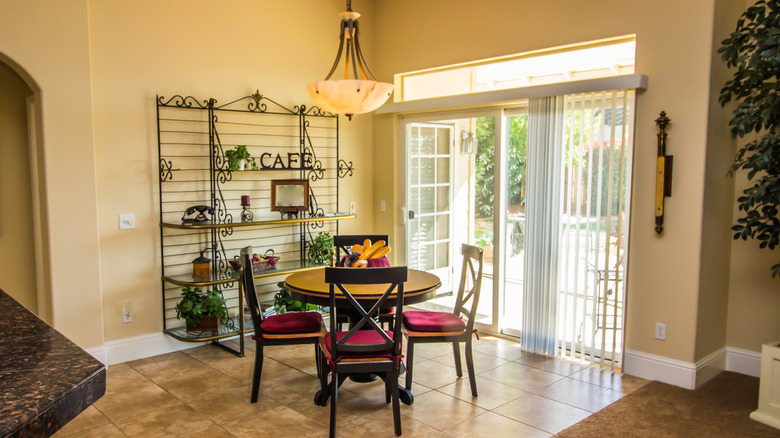 Kitchen with sliding glass door and vertical blinds.
