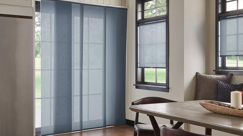 Blue panel track shades cover a sliding door in a residential kitchen.