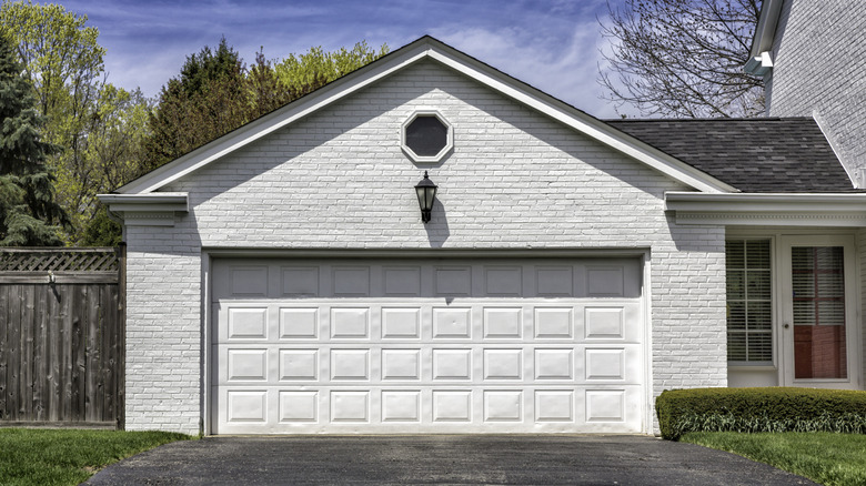 A white-washed brick facade of a home and garage
