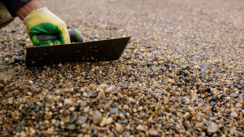 Person leveling the surface of a gravel driveway