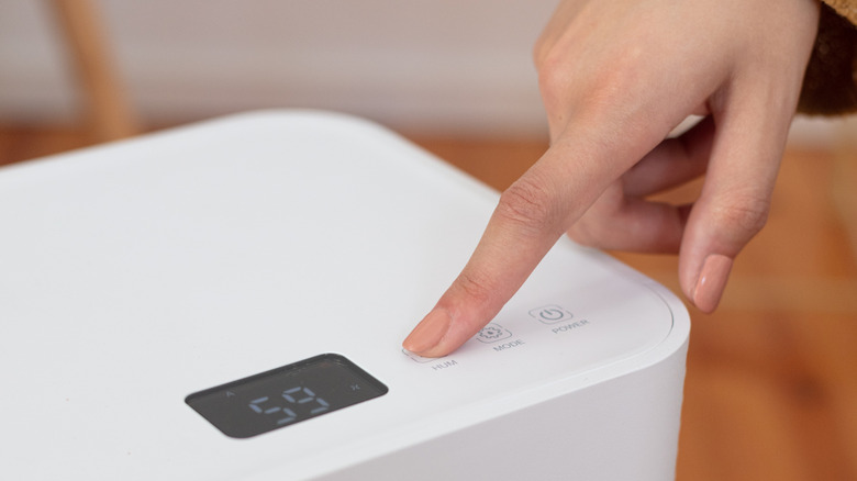 a person turning on a dehumidifier