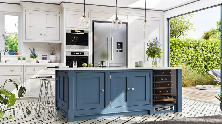 Blue kitchen island in a bright, white, airy kitchen.
