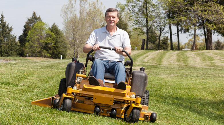A man on a zero-turn lawn mower