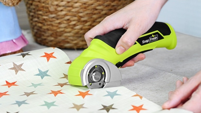 Person using the SnapFresh electric cutting tool to cut some gift wrapping paper