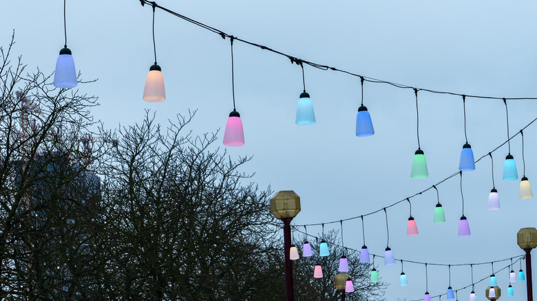 Pastel multicolor LED string lights hanging from lamp posts