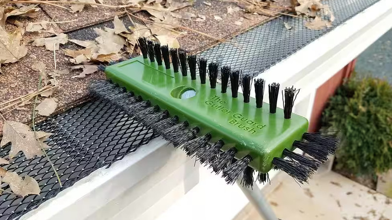 The Gutterglove Gutter Guard Brush from Home Depot cleaning a guarded gutter