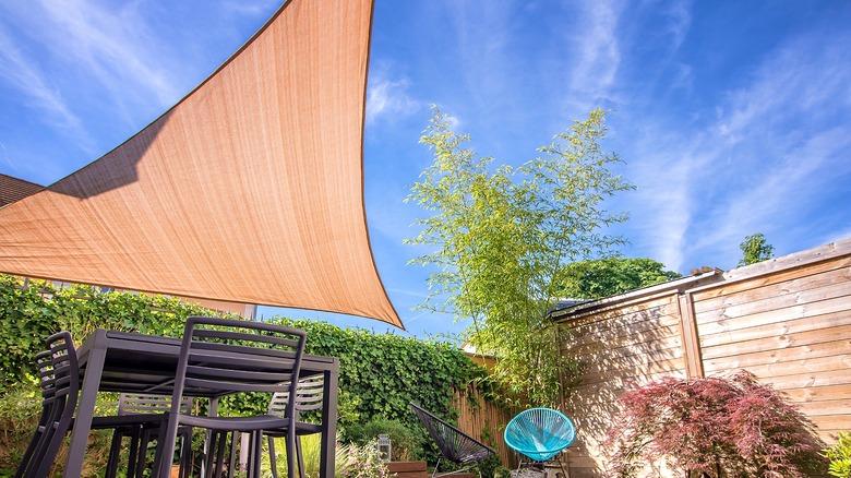 Patio and backyard with a sun shade sail covering it