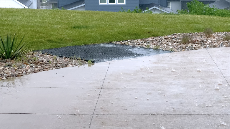 Rainwater accumulates on a patio made of solid pavers