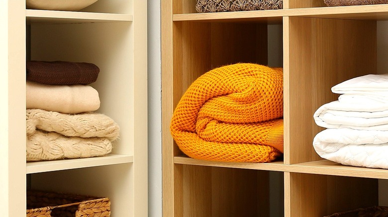 Various cubbyholes filled with blankets in brown, cream, orange, and white