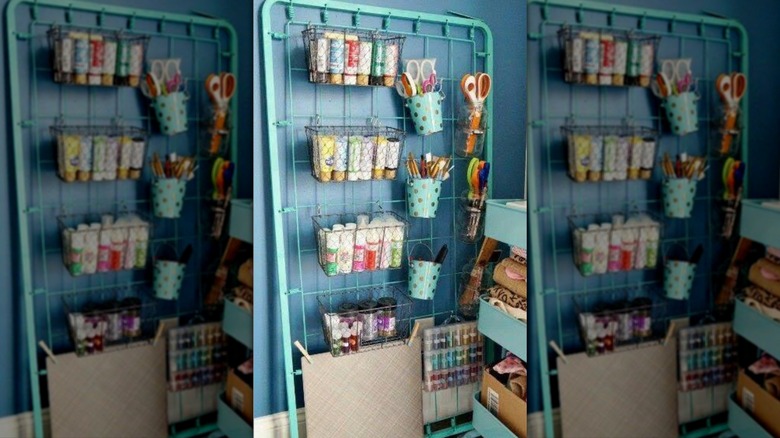 Old metal bed frame painted blue and used as storage unit in craft room.