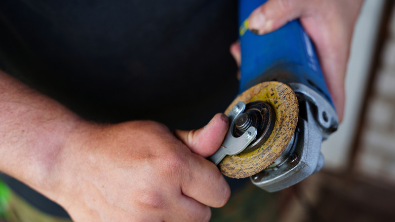 Man removing or tightening disc on an angle grinder