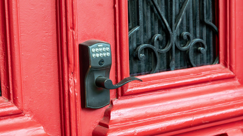 A keypad lock on a bright red door