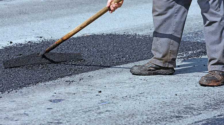 Person filling a pothole