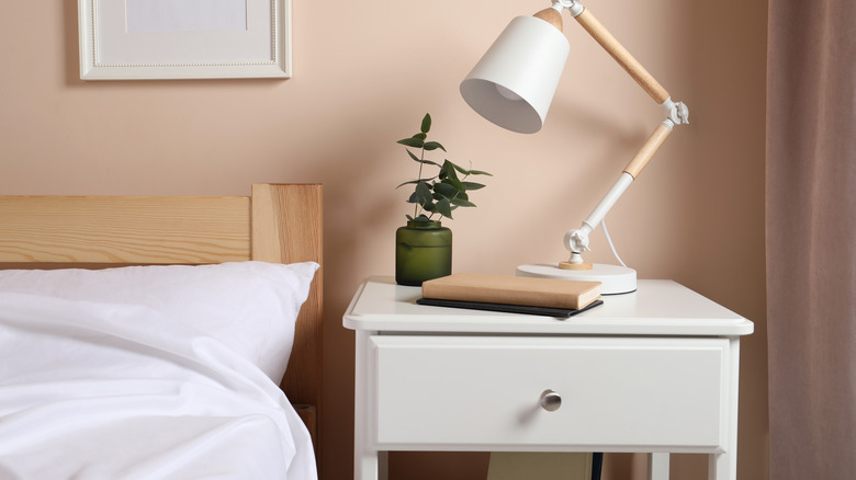 Cozy nightstand setup with a lamp, plant, and book