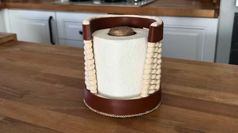 A toilet paper dispenser make from a lid, skewers, and a dowel