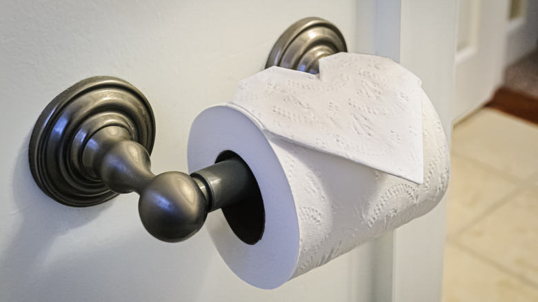 A roll of toilet paper on a metal dispenser