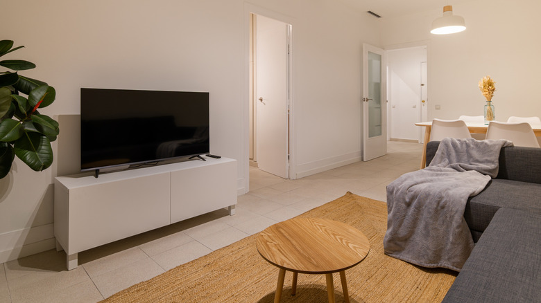 minimal living room with plain white tv console and tv on top